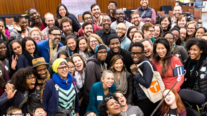 A group of people posing for a photo in front of a crowd