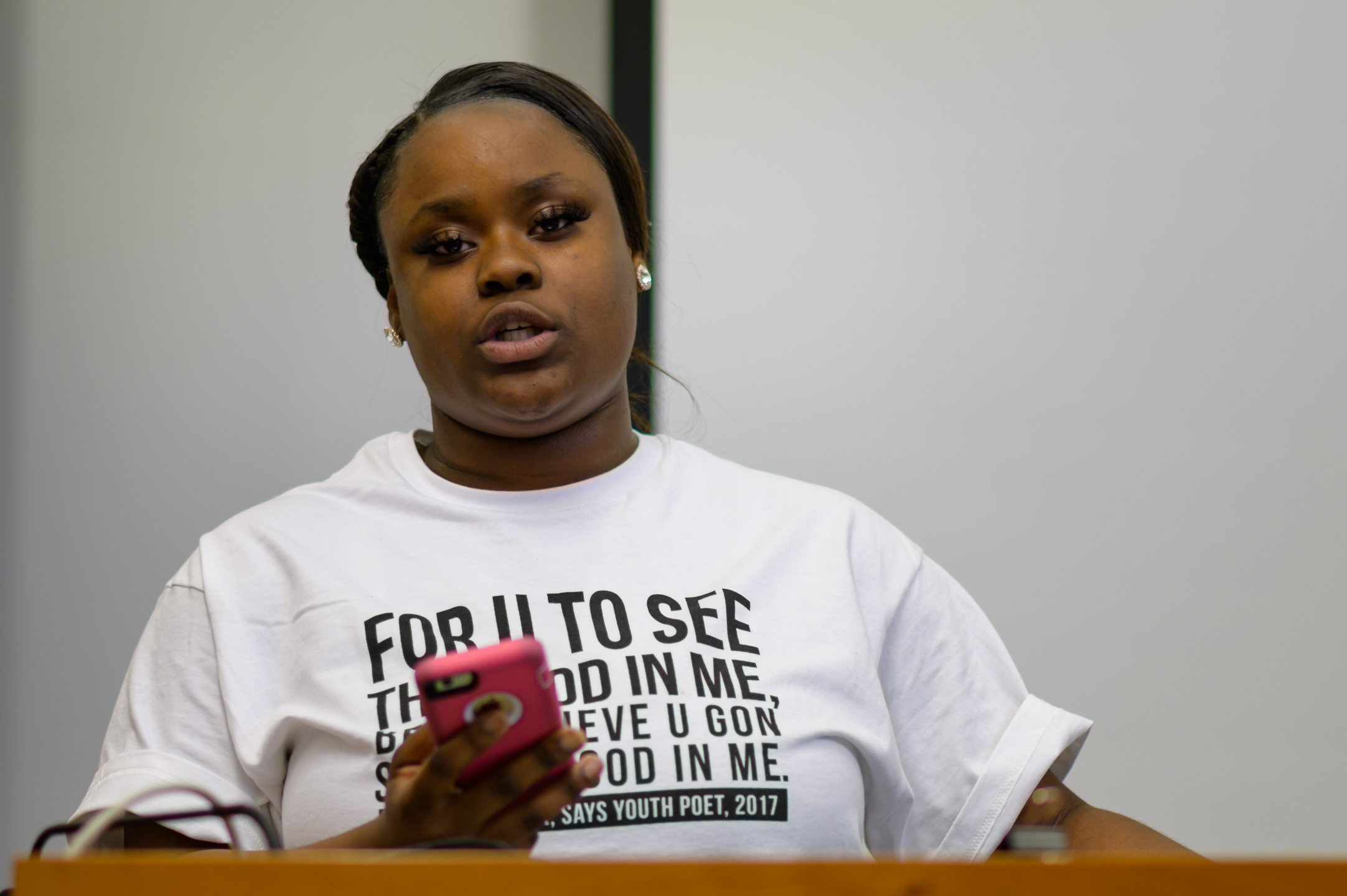 Marquisha B., medium close up at the lectern, performing spoken word