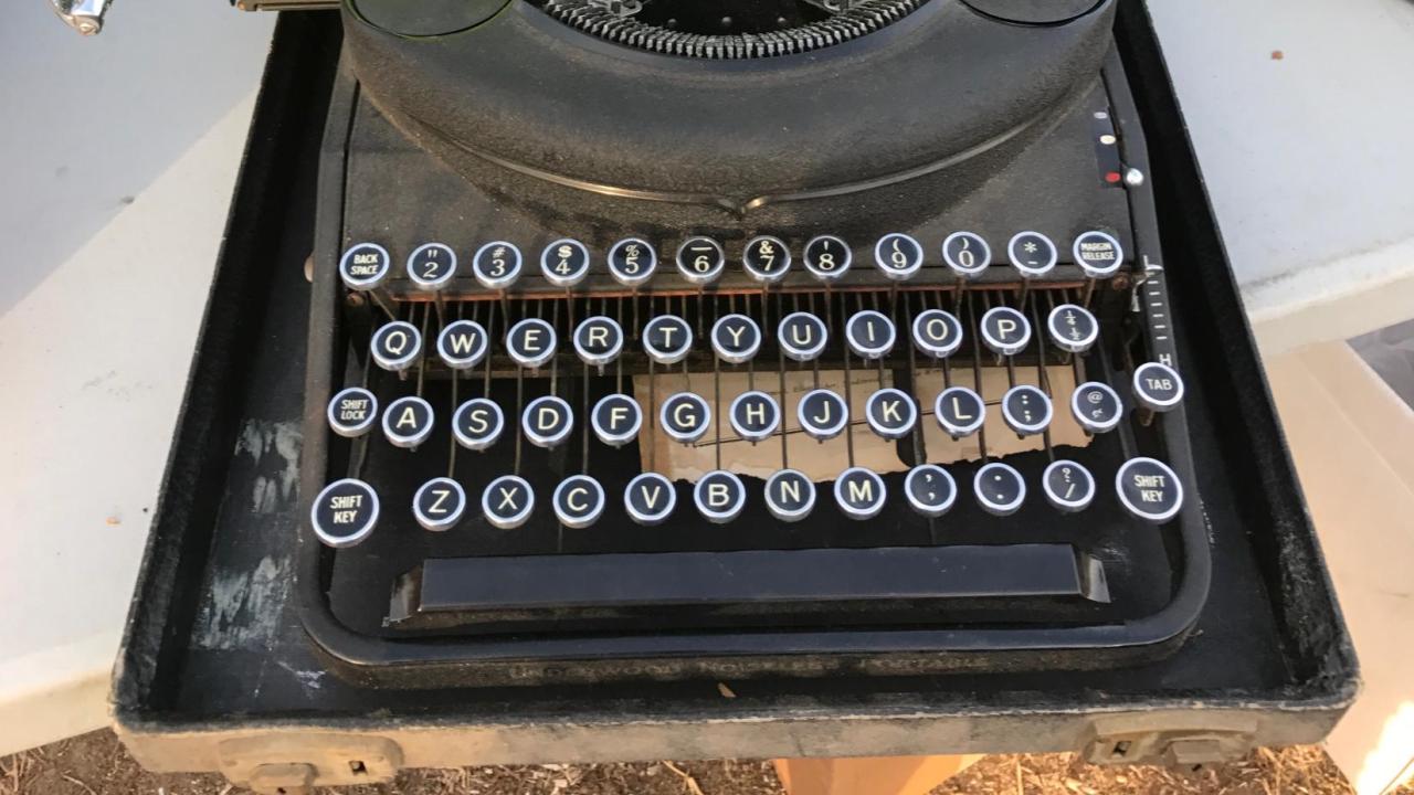 Black typewriter with green paper 