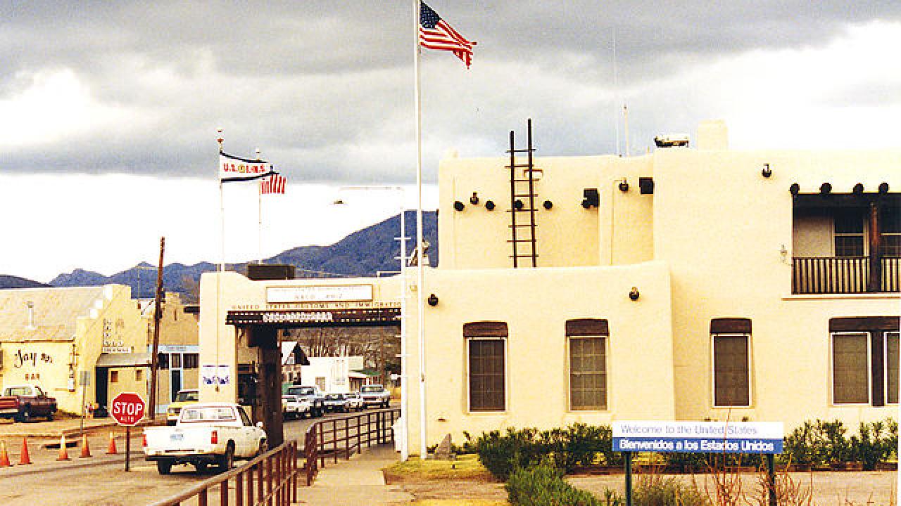 Border station at Naco, Texas. White adobe structure with U.S. flag flying overhead