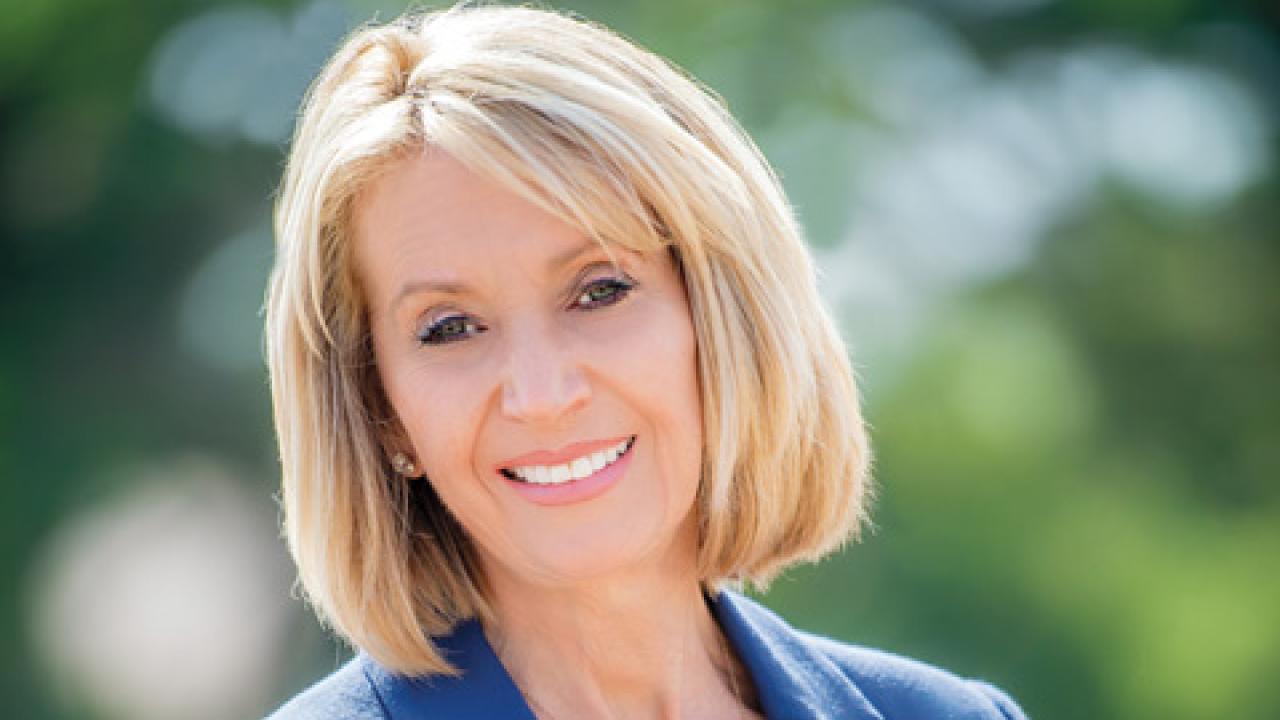 Marcia McNutt wearing blue blazer over red shirt looking at camera