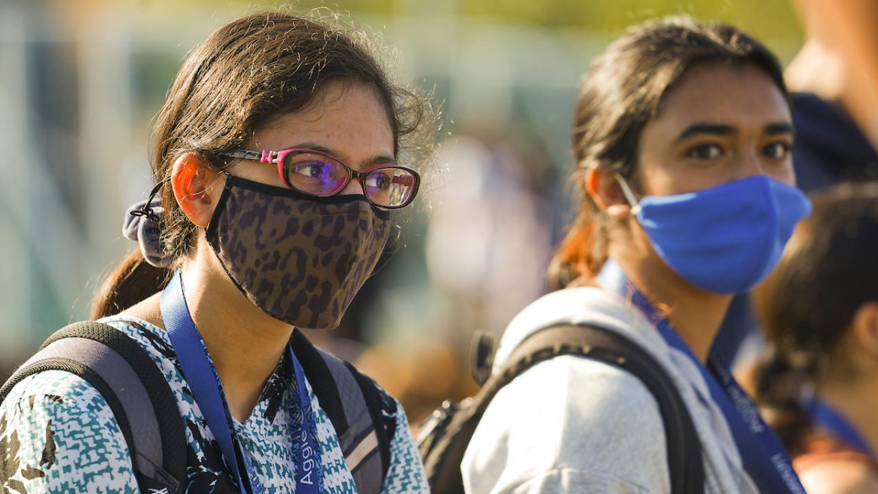 Two students outside wearing masks