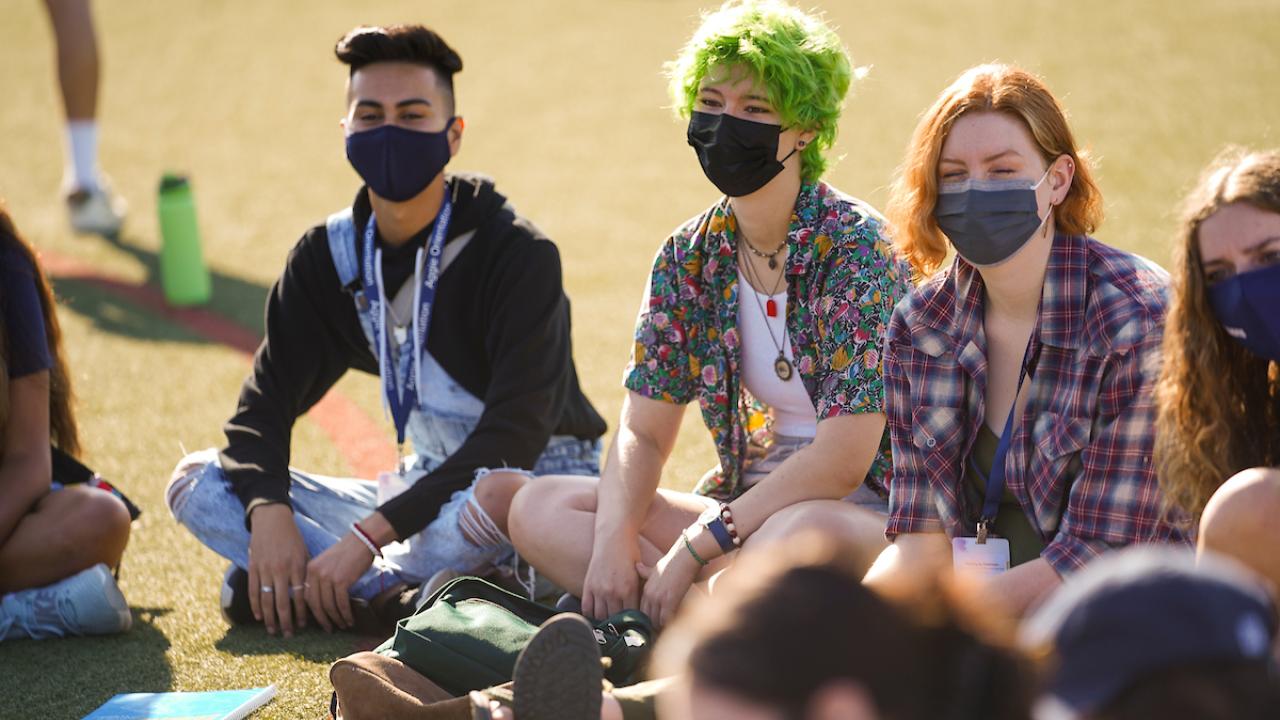 Four students gathered outside having a meeting