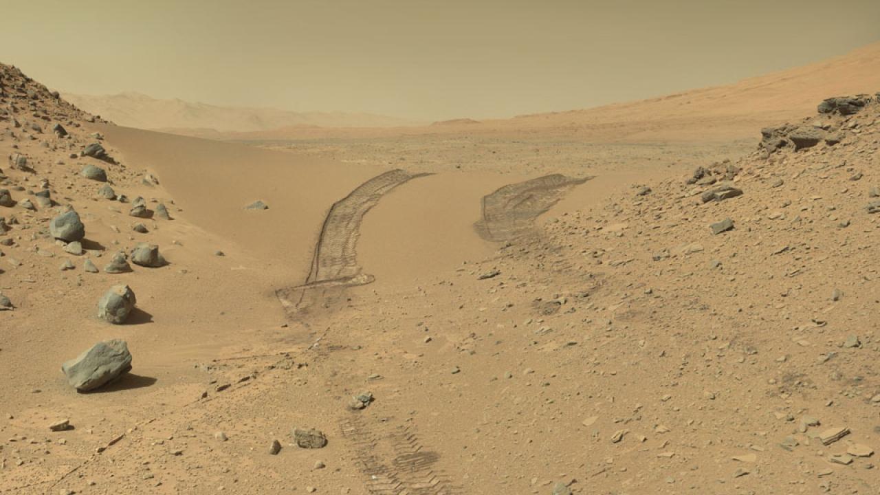 Crossing the Dingo Gap on Mars, a valley of red sand and rock with dusty sky