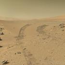 Crossing the Dingo Gap on Mars, a valley of red sand and rock with dusty sky