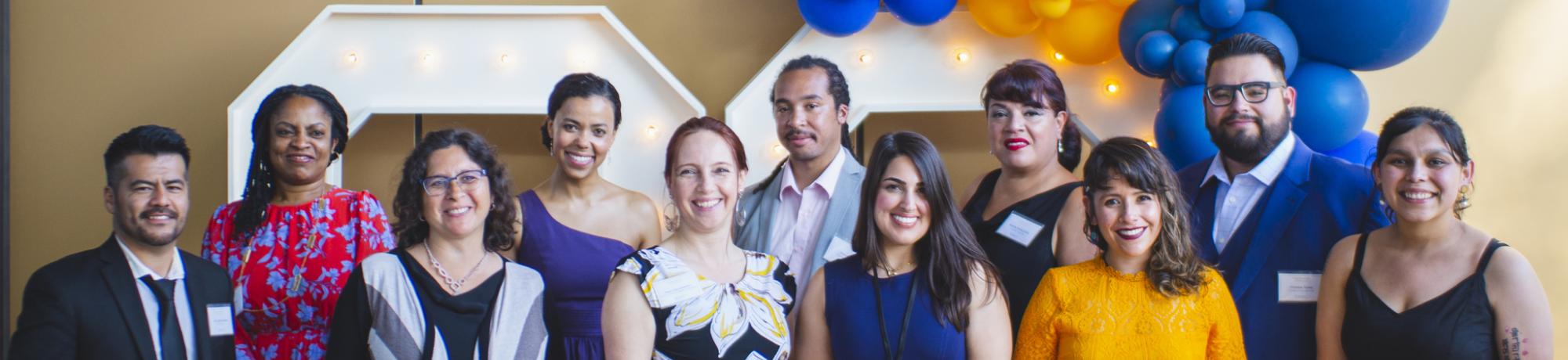 The 2021-22 EJ Fellows and leadership team dressed in formal attire standing smiling.